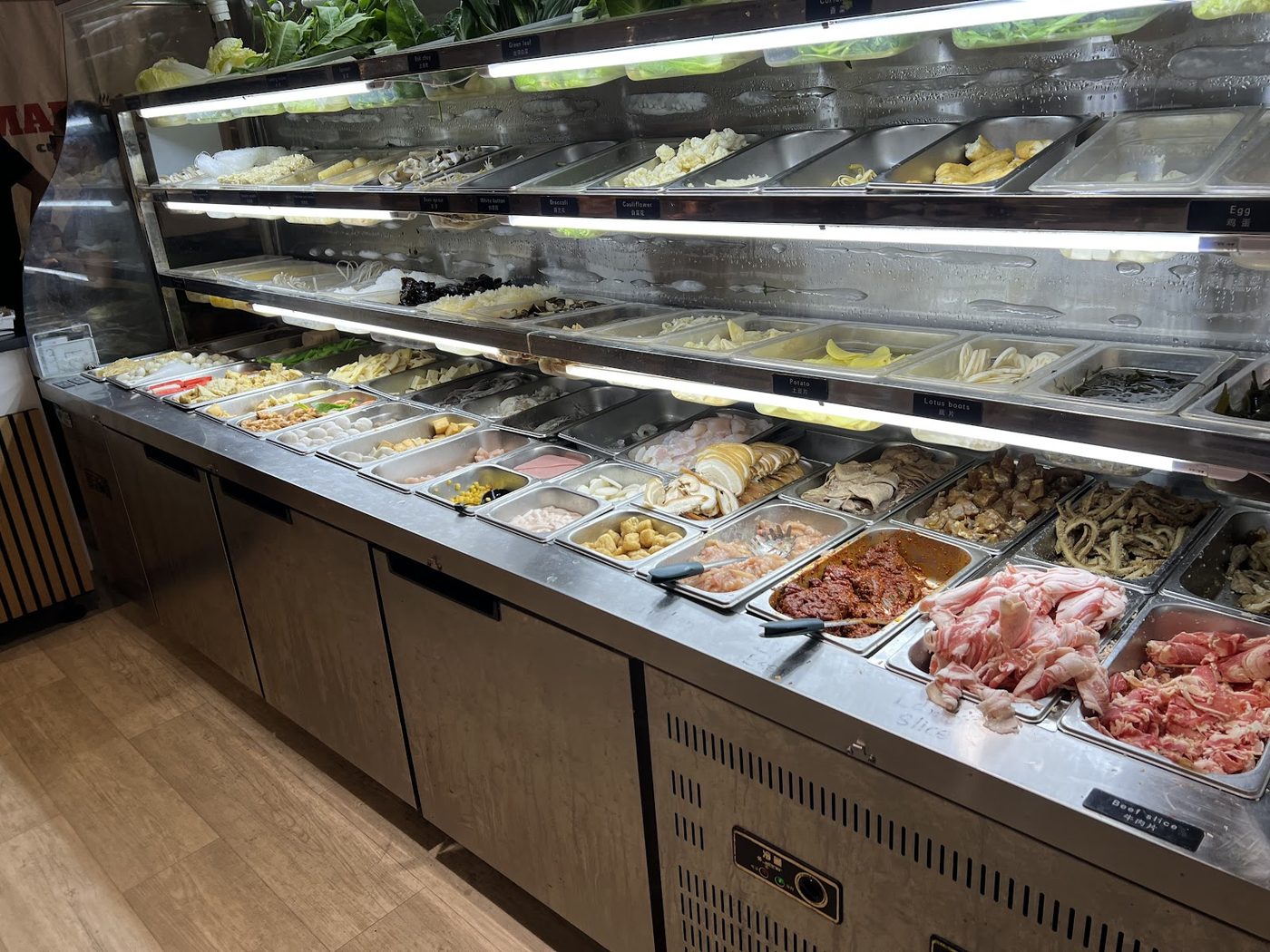 Mad pot ingredient display with vegetables, tofu, meatballs and other ingredients ready to select